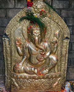 Ornate golden relief of the Hindu deity Ganesha, with carefully crafted details. 