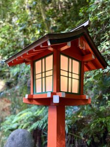 A traditional Japanese garden lantern nestled among lush greenery, bringing a sense of peace and harmony to the surrounding landscape.