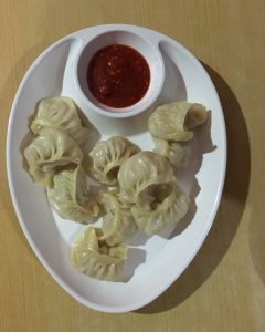 Steaming hot momos – Nepal’s favorite comfort food, filled with delicious flavors and served with a spicy dipping pickle. 
