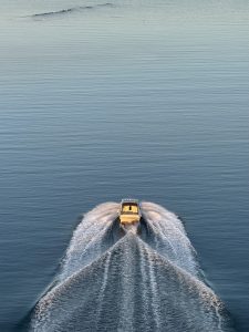a white motorboat gliding smoothly across the water, leaving a wake in its wake
