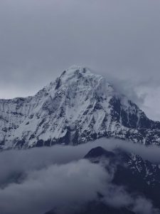 A close up look of Mount Annapurna, where the snow, cloud and sky is clearly visible.