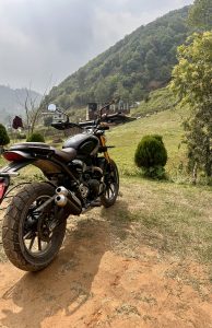 A bike standing on the backdrop view of green landscape with mountains ready to take the next ride 