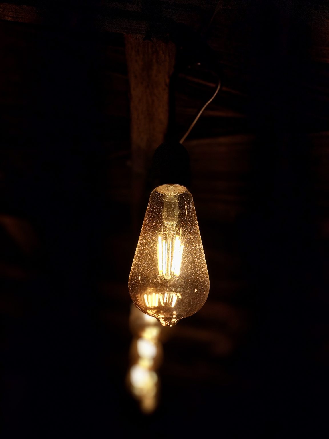 A glowing pendant light against a dark interior.