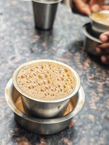 Filter coffee served in a steel glass with a cup under the glass 