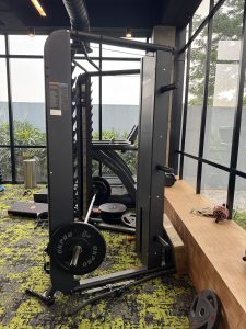 A gym with a Smith machine, weights, and exercise equipment.