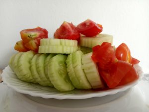 sliced cucumber and tomato served in a white plate 