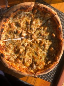 A close up of a freshly baked chicken pizza with golden melted cheese 