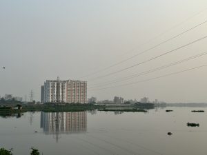 Reflection of a tall building in the water body. 
