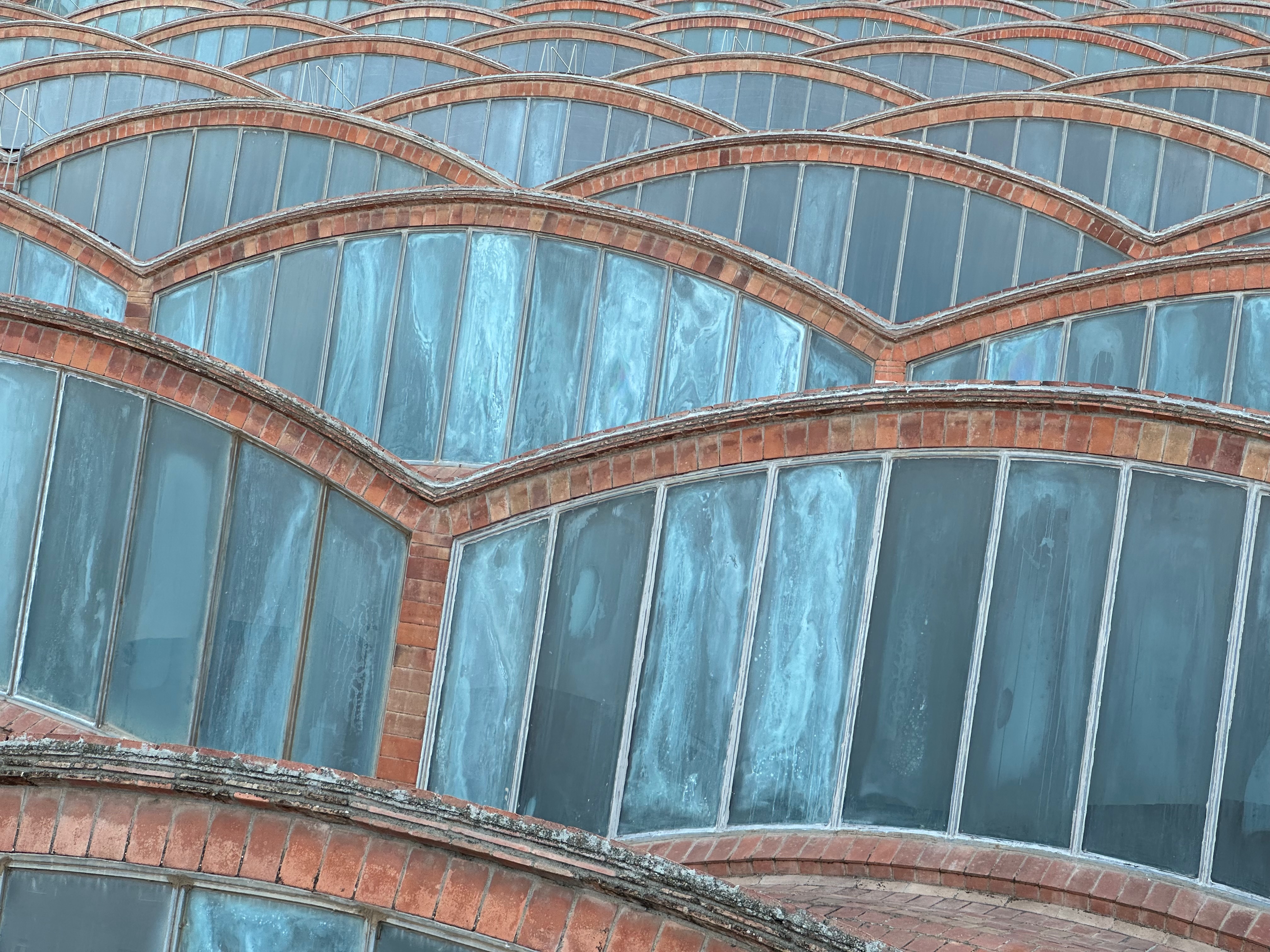 Modernist rooftop conforming a wavy pattern, composed by bricks and glass