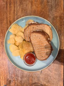 Grilled Sandwich with some chips on the side. 
