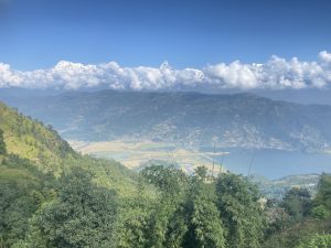 A sweeping panoramic view of Pokhara valley with Phewa Lake and the Annapurna mountain range with Machhapuchhre peak rising above the clouds. 