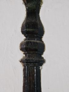 A close-up view of a polished wooden pillar reveals fine craftsmanship and traditional design. The smooth curves and aged texture highlight the beauty of historic wooden architecture. Captured at Arakkal Museum, Arakkalkettu, Kannur, Kerala.