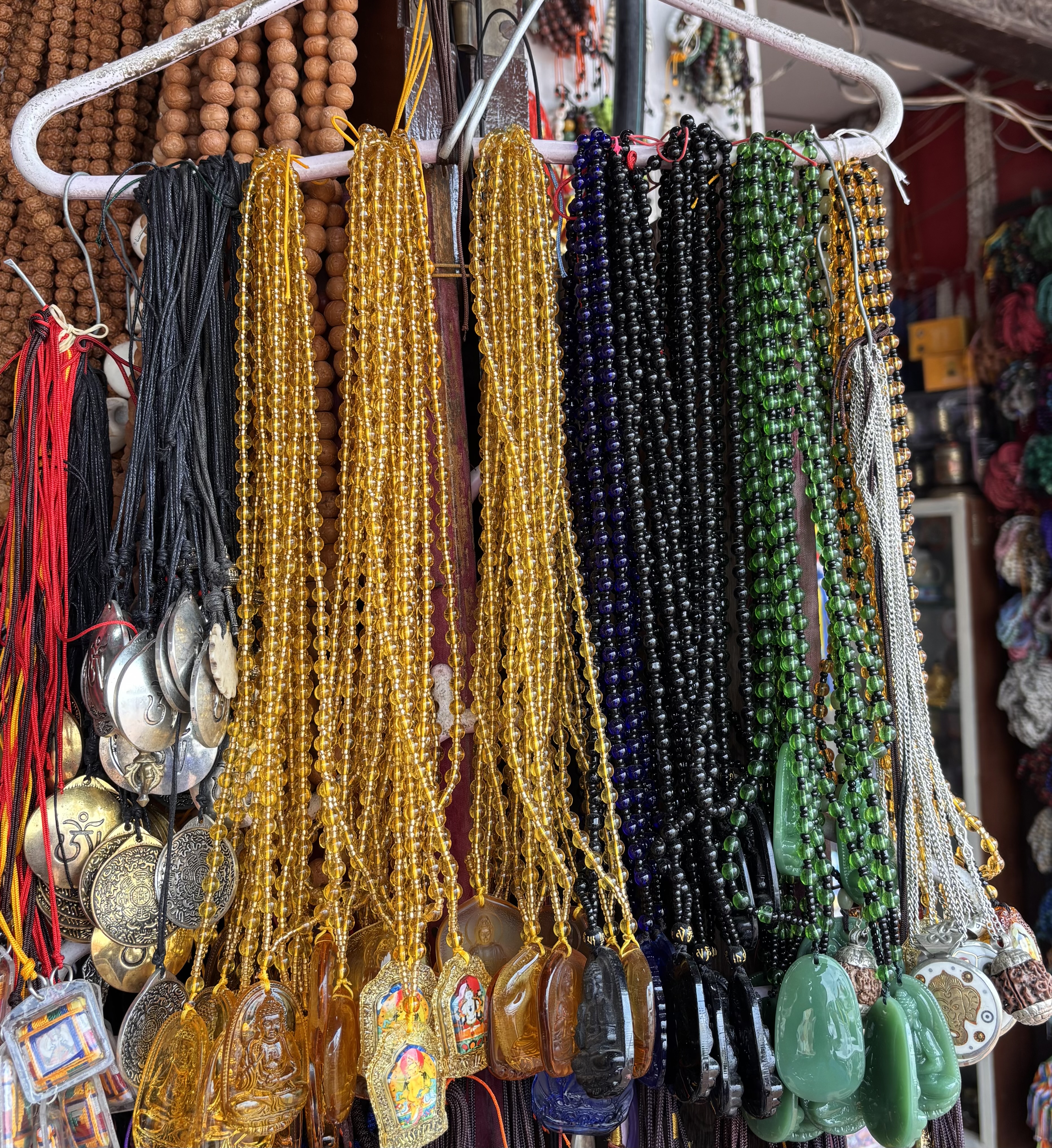 A display of colorful beaded necklaces hanging from a rack.