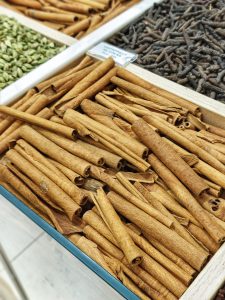 A display of cinnamon sticks in a wooden tray