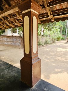 A beautifully carved pillar supports the shaded veranda of the heritage mansion. The aged timber and tiled roof showcase traditional Kerala architecture. Captured at Varikkasseri Mana, Vaniyamkulam, Palakkad