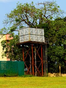 A view of a water tank near a green house 
