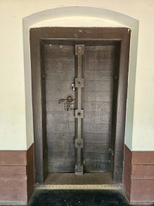 A sturdy wooden entrance door with traditional iron fittings reflects the craftsmanship of Kerala's historic homes. Its simple design highlights the mansion's heritage. Captured at Varikkasseri Mana, Vaniyamkulam, Palakkad.
