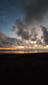 Sunset in a beach on tropical location with cloudy sky. 