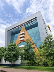 12:38 PMClaude responded: Bold contemporary corporate building with a striking gold arrow-shaped facade set against reflective blue glass panels and a cloudy sky #NepalPhotoFestival2026Bold contemporary corporate building with a striking gold arrow-shaped facade set against reflective blue glass panels and a cloudy sky