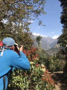Photographer in Blue Jacket Capturing the Majestic Snow-Capped Peaks of the Himalayan Mountain Range. 

