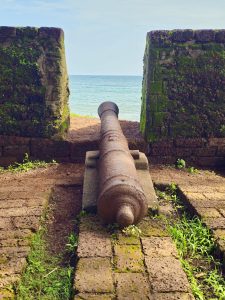 An old cannon stands between the fort walls, pointing toward the Arabian Sea. The historic structure, weathered stones, and coastal backdrop highlight the fort’s strategic importance. Captured at St. Angelo Fort, Kannur, Kerala
