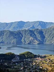 Aerial view of Phewa Lake with the World Peace Pagoda crowning a forested hillside above Pokhara city, Nepal 