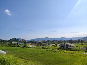 Fish farming ponds and green fields on the outskirts of Pokhara city with mountain backdrop 