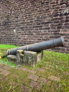 An old iron cannon rests beside the laterite stone walls of St. Angelo Fort, overlooking centuries of history. The weathered structure and moss-covered ground reflect the fort’s military past. Captured at St. Angelo Fort, Kannur, Kerala.
