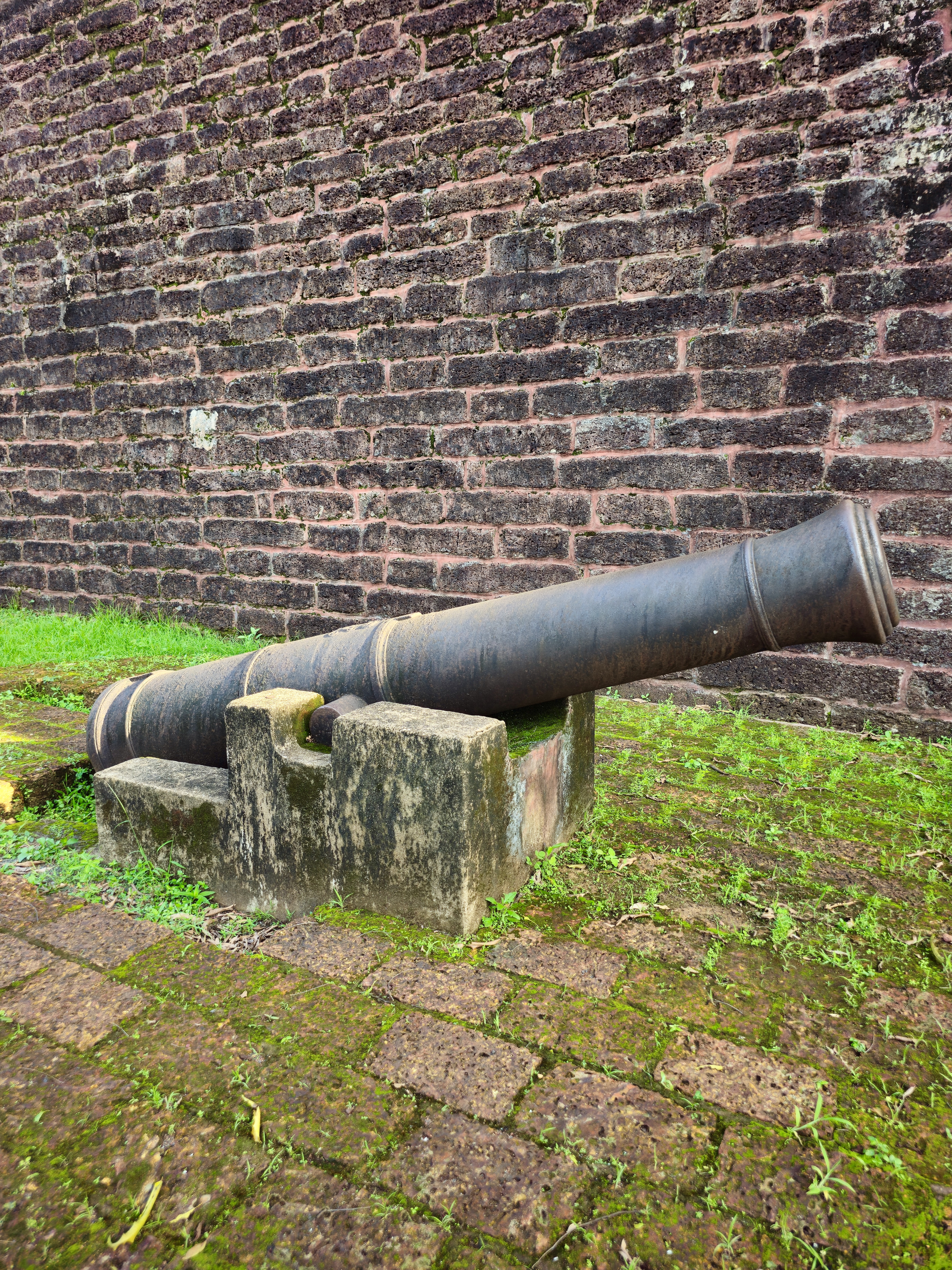 An old iron cannon rests beside the laterite stone walls of St. Angelo Fort, overlooking centuries of history. The weathered structure and moss-covered ground reflect the fort’s military past. Captured at St. Angelo Fort, Kannur, Kerala.