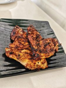 Grilled, seasoned chicken fillets on a black square plate