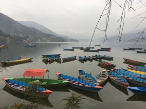 Colorful boats floating peacefully on the beautiful waters of Phewa Lake, Pokhara.