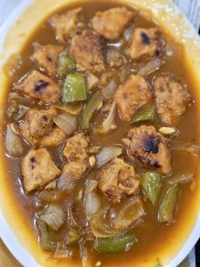 A plate of Chicken Manchurian with juicy chicken pieces, onions, green peppers, and a rich, flavorful gravy. A delicious Indo-Chinese dish served hot and fresh. Captured in Palazhi, Kozhikode, Kerala.