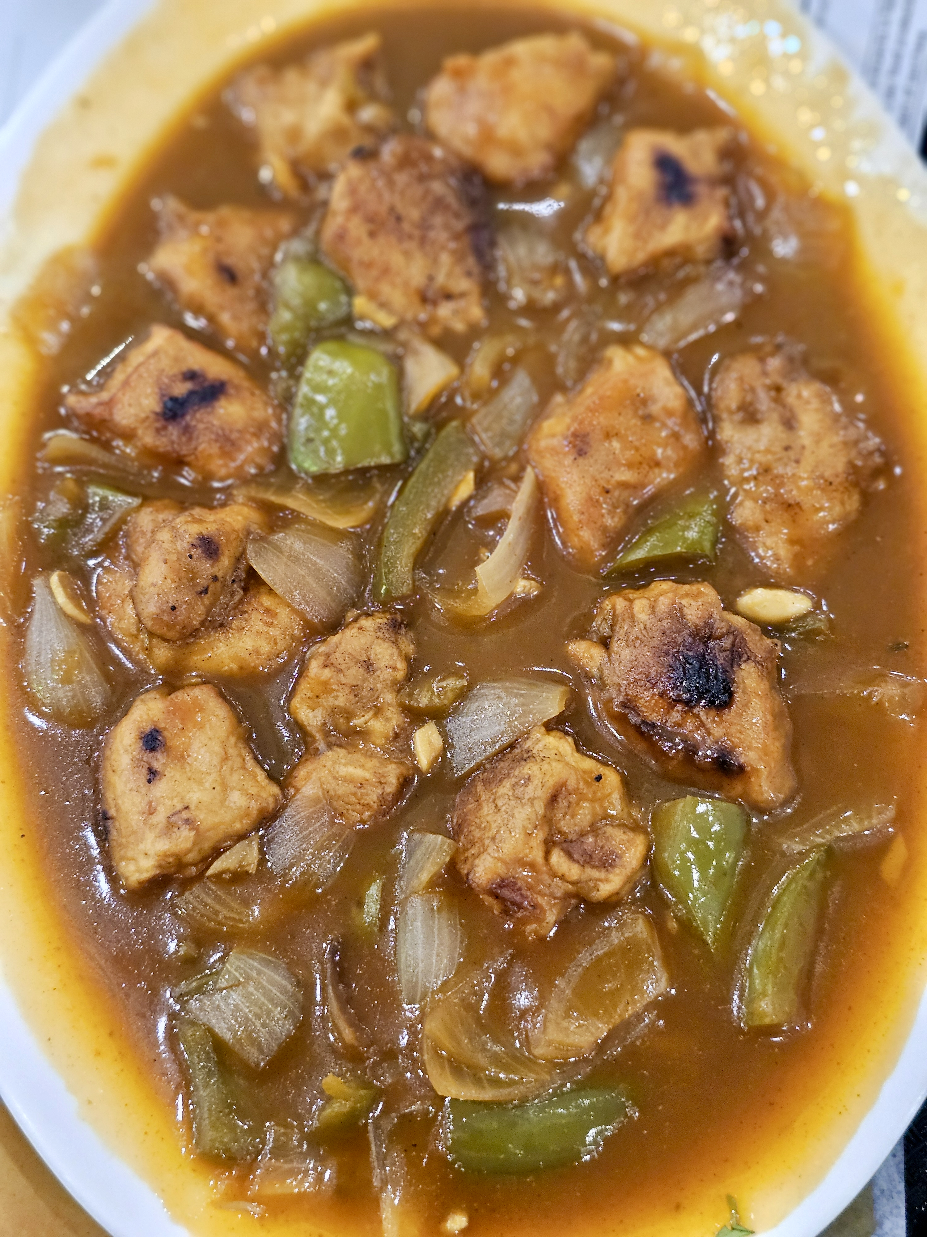 A plate of Chicken Manchurian with juicy chicken pieces, onions, green peppers, and a rich, flavorful gravy. A delicious Indo-Chinese dish served hot and fresh. Captured in Palazhi, Kozhikode, Kerala.