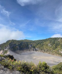 
A volcanic crater surrounded by green cliffs and rugged rocky terrain.