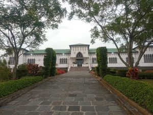 Front entrance of the Municipal Museum of Cartago, Costa Rica. Historic building with Gothic-style architecture, green roof and arched windows, framed by a stone pathway and lush garden landscaping.