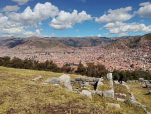 View of the city of Cusco from the top of Sacsayhuaman, Peru. The urban landscape extends across the valley, surrounded by hills and mountains, with the historic city visible below the archaeological site.