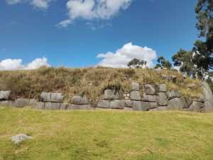 Remains of an Inca stone wall at Qenqo Chico, partially covered by vegetation.