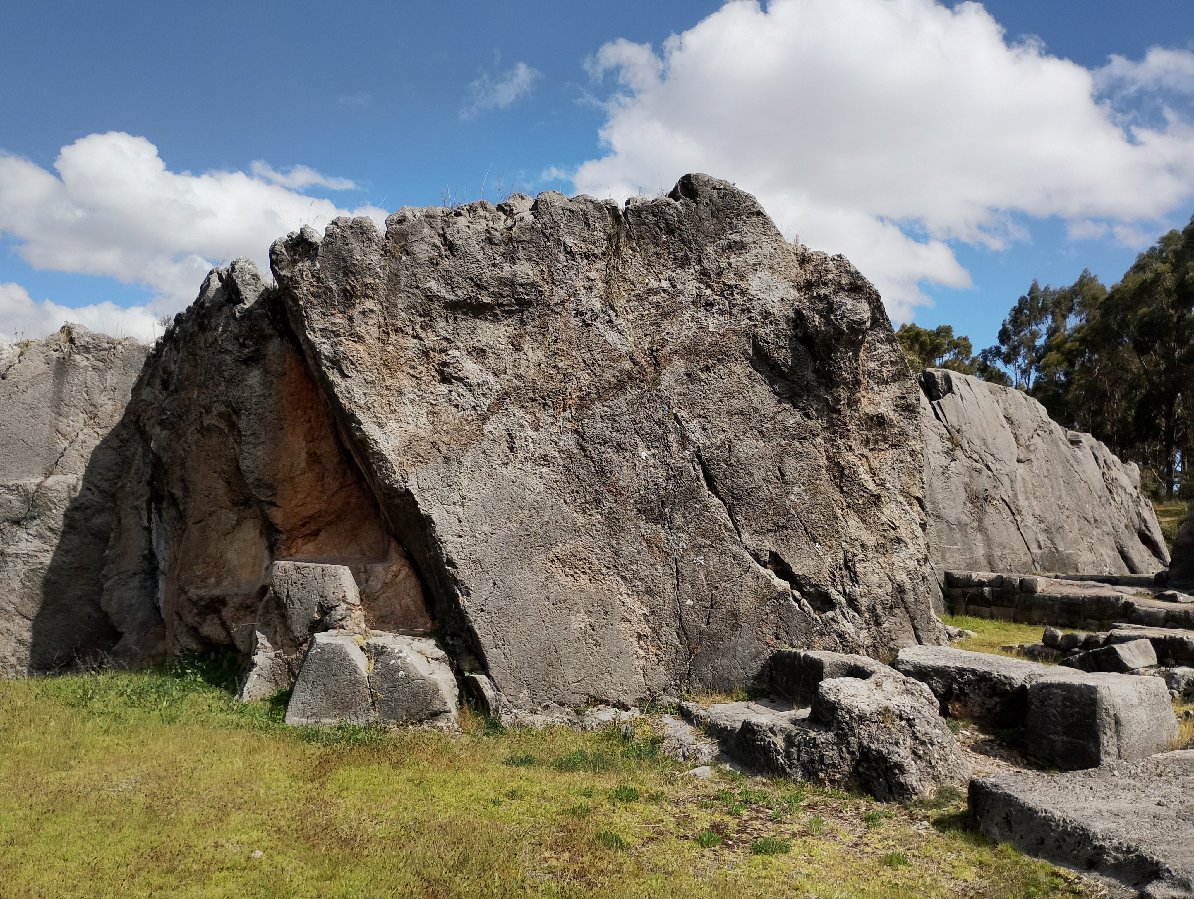 Partially carved natural rock formation at Qenqo, an Inca archaeological site near Cusco. The exposed stone features carved surfaces shaped by the Incas while preserving the natural contours of the original rock.