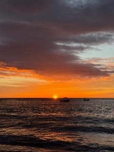 Vibrant sunset over the ocean with colorful sky and dramatic clouds.
