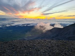 A sunrise view from a high volcanic mountain landscape.
