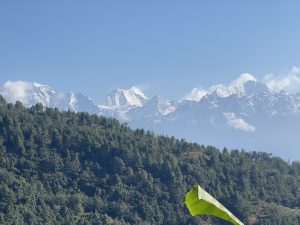 A panoramic view of majestic mountains topped with snow, rising against a clear blue sky.