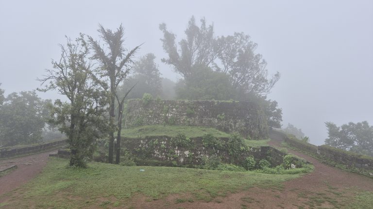 A misty landscape featuring ancient stone ruins set against a backdrop of dense fog.