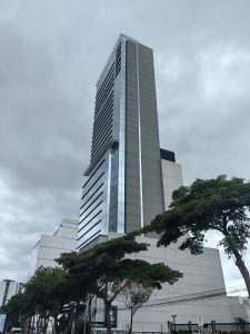 A low-angle view of a tall building against a cloudy sky.