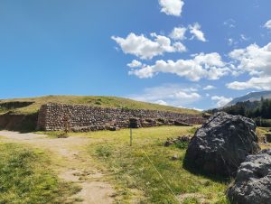 Stone wall at Sacsayhuaman made of small stacked stones, with an earthen terrace behind it.