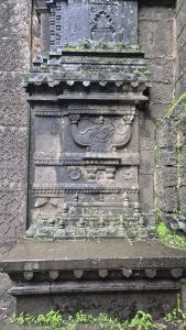 Detailed stone temple structure with carvings and moss.
