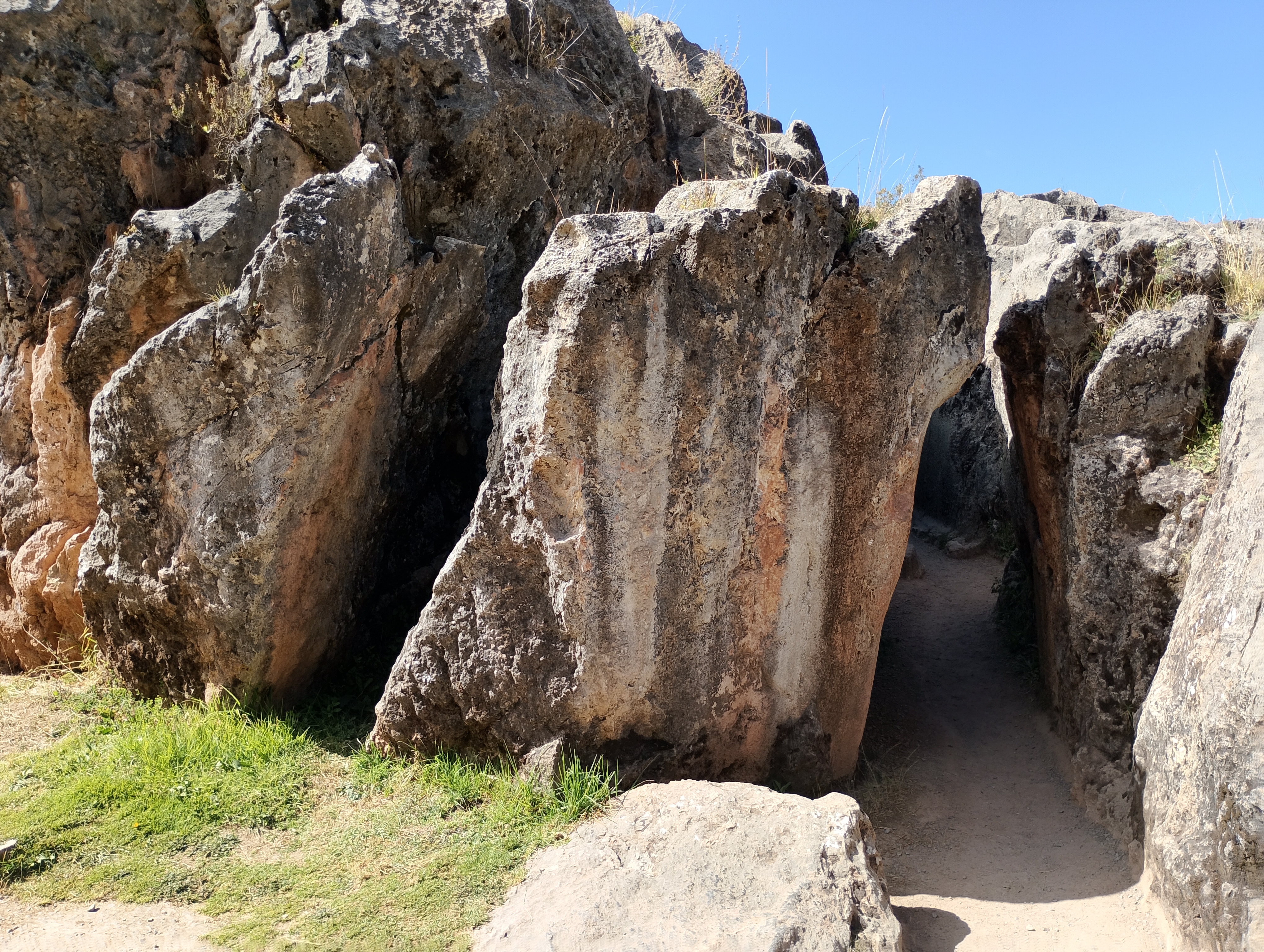 A narrow stone passage at Qenqo, an Inca archaeological site near Cusco, surrounded by natural rock walls.