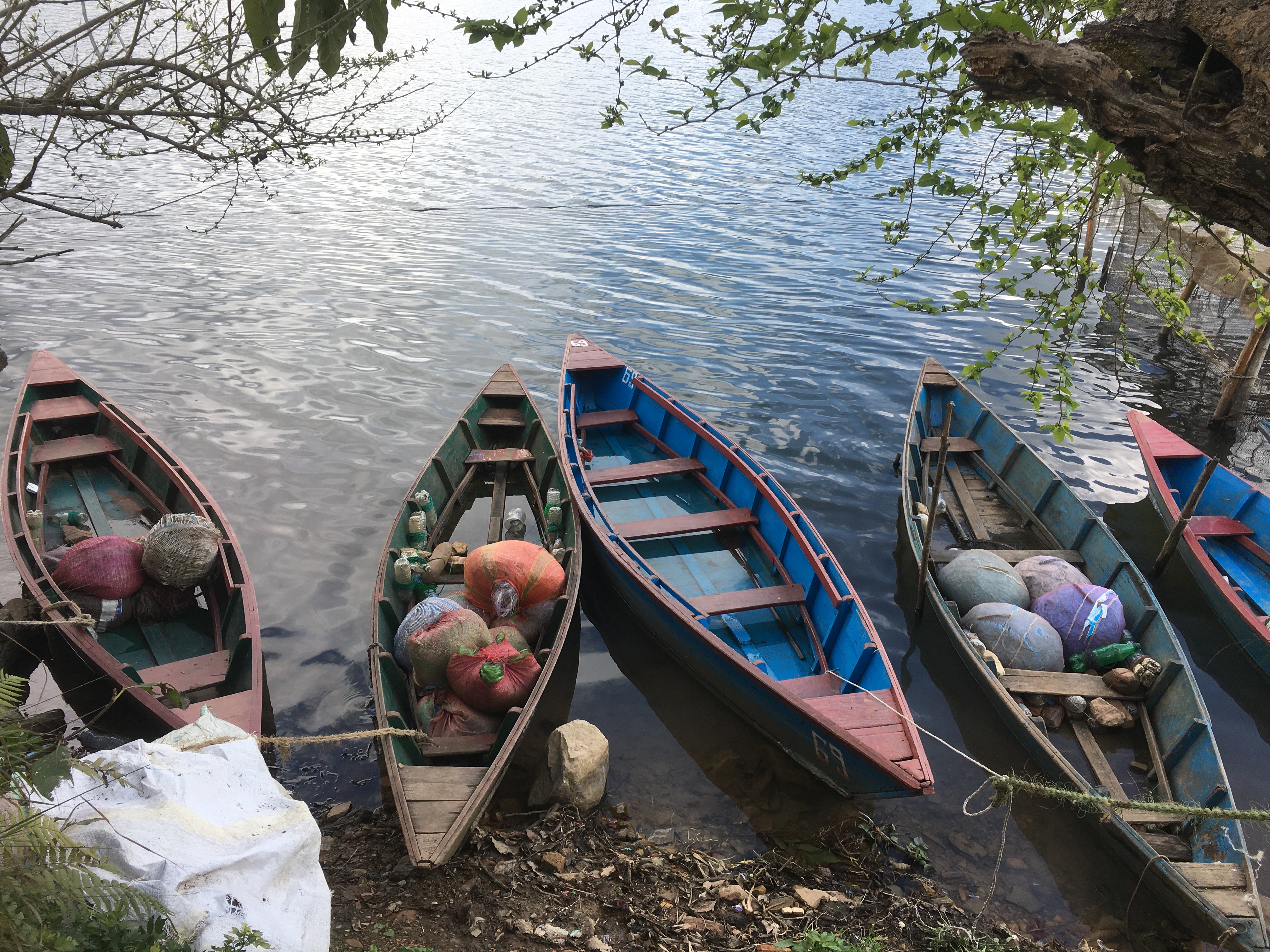 A colorful boat drifting across the tranquil waters of Begnas Lake, Pokhara.