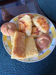 Plate of baked pastries with melted cheese on a textured blue surface.