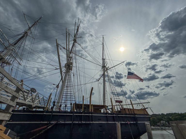 The sun begins to set over the 1841 whaling ship, Charles W. Morgan, at Mystic Seaport in Connecticutt, USA.