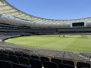 Interior view of Optus Stadium in Perth, showcasing the seating tiers, playing field, and modern roof structure.
